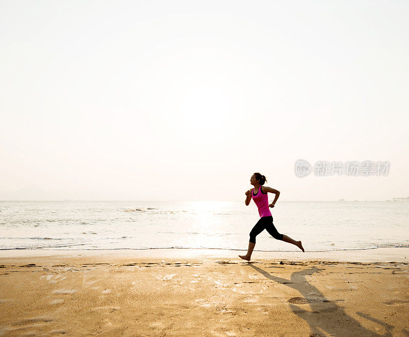 日出时，一个女人在岸上慢跑