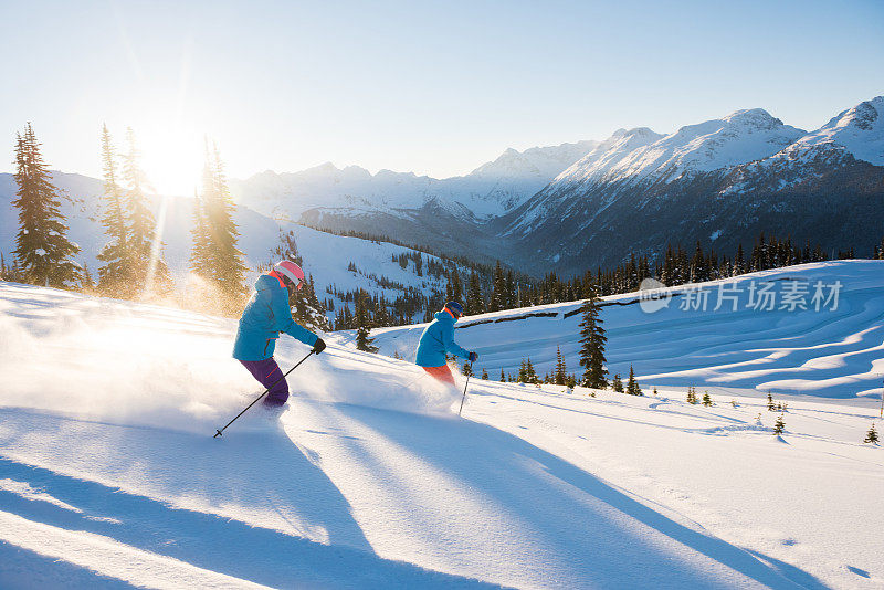 一对夫妇在阳光明媚的雪天滑雪