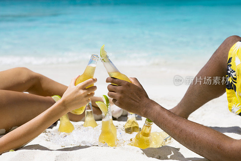 一对夫妇在加勒比海滩上晒日光浴，然后敬酒