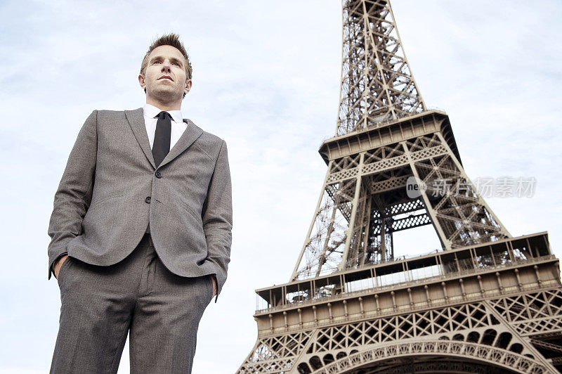 法国巴黎，一个商人站在埃菲尔铁塔外面