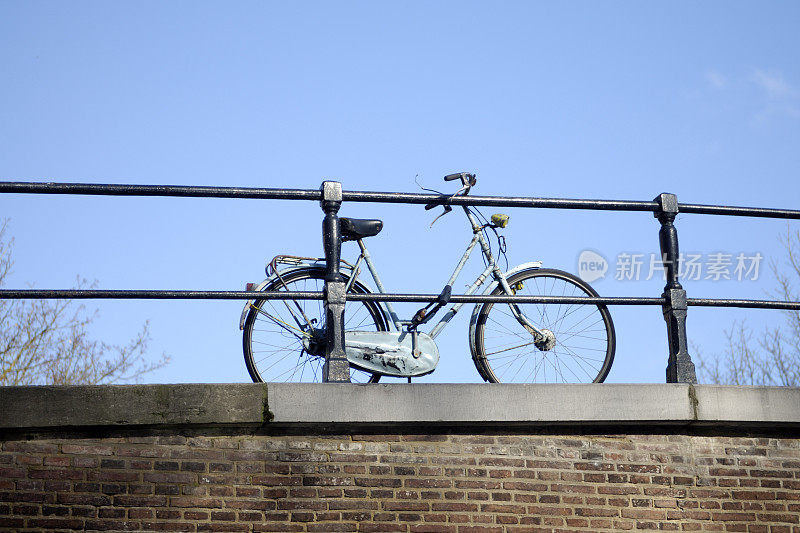 一辆荷兰自行车靠在石桥的栏杆上