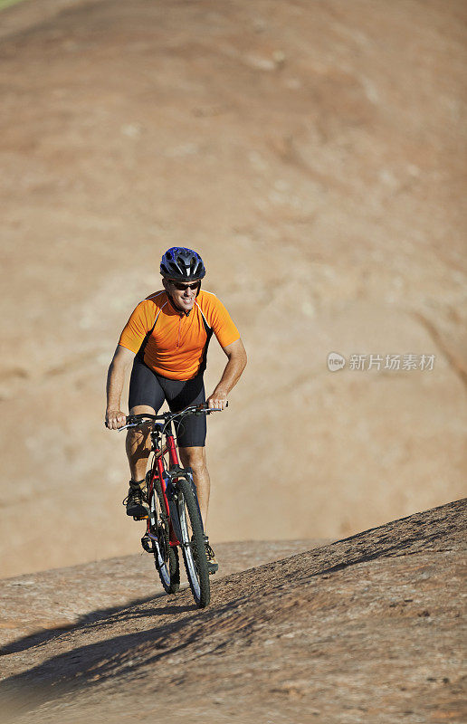 男运动员骑山地车滑岩小径，犹他州