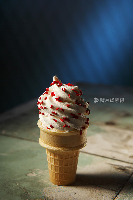 香草软冰淇淋装在一个普通的蛋筒里，配上红色的卷边。