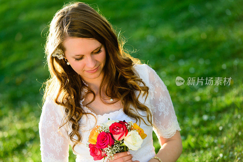 美丽的新娘看着花束-水平
