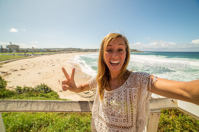 愉快的年轻女子在澳大利亚邦迪海滩上自拍