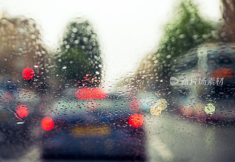 雨中车流散乱，雨点落在挡风玻璃上