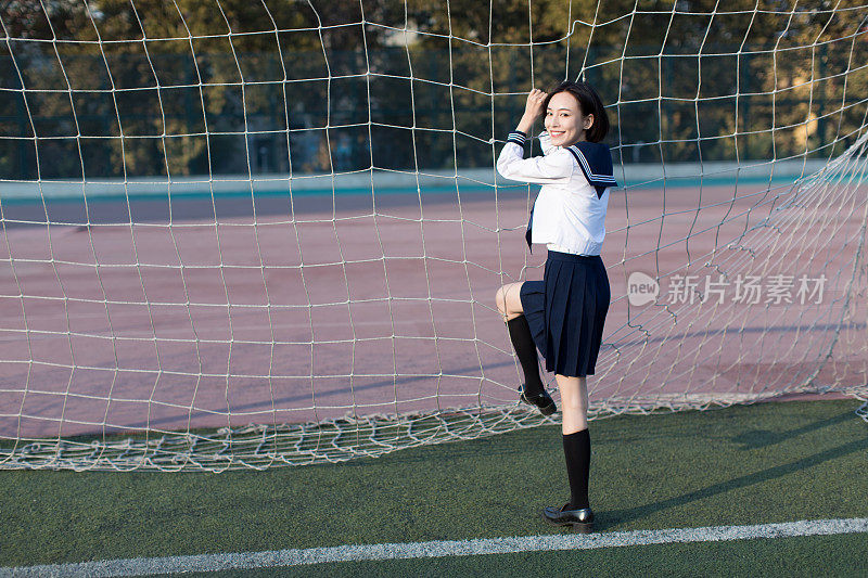 宽阔的足球场里有一个美丽的中国女学生