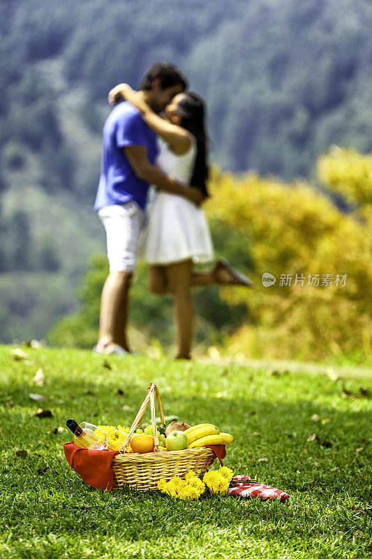接吻和相爱的拉丁幸福夫妇享受野餐在公园
