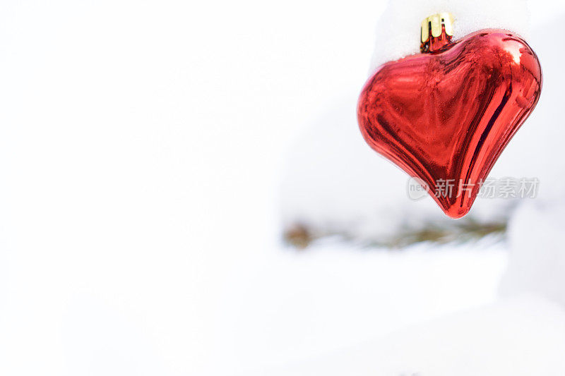 红色和闪光的情人心在雪的背景