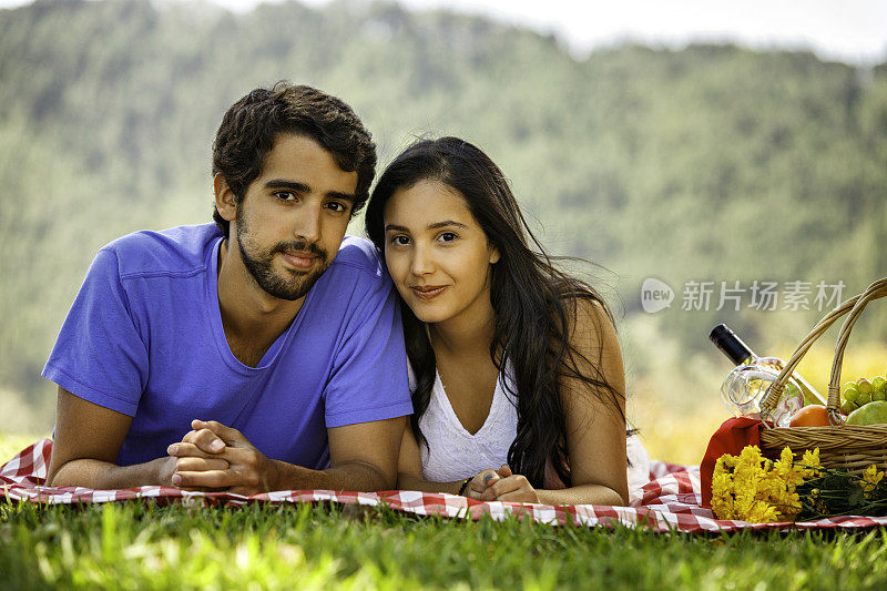 自信拉丁幸福的夫妇享受野餐在草地