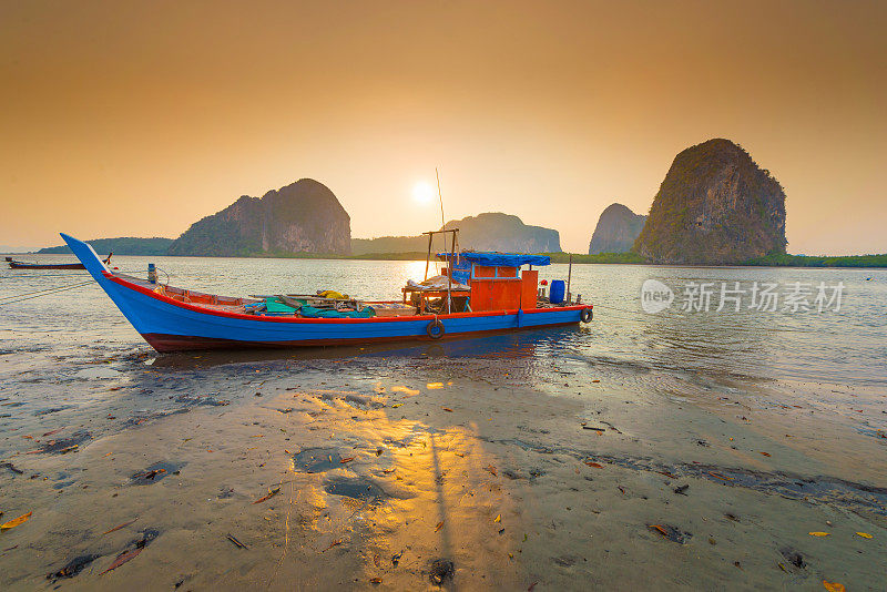 美丽的日落在热带海洋与长尾船在泰国南部