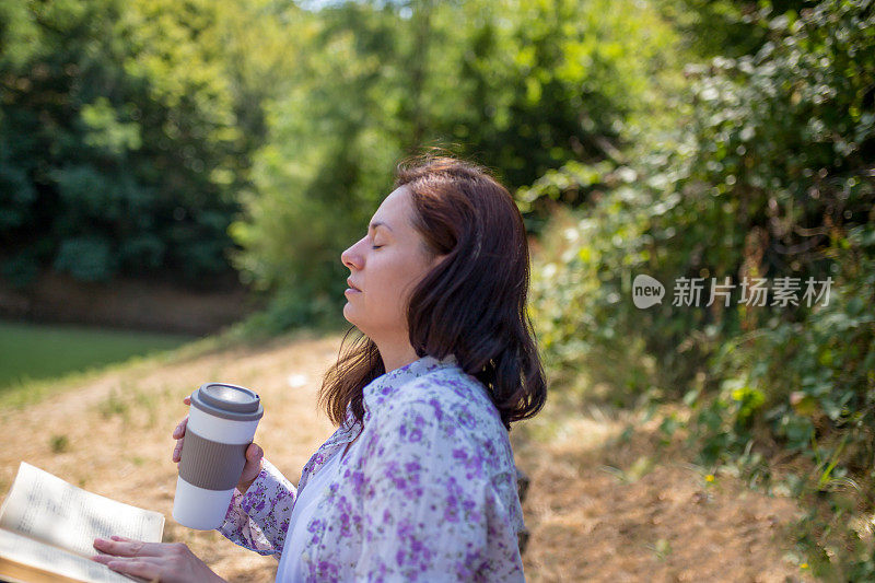 一个年轻女子坐在夕阳下的湖上看书。