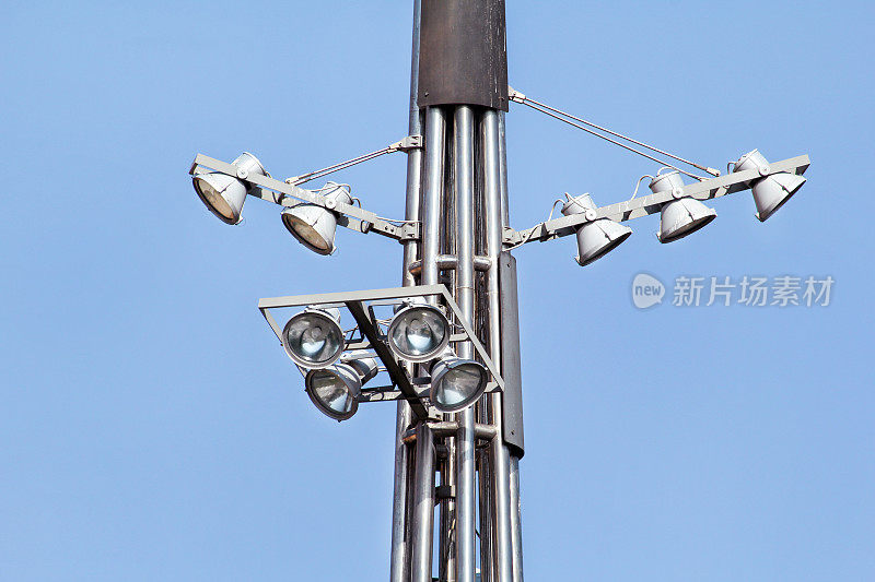 在城市道路和街道的环岛上有反射器的塔。蓝天灯杆。大灯和灯光的体育场杆子或体育照明。投光杆塔在聚光灯下。