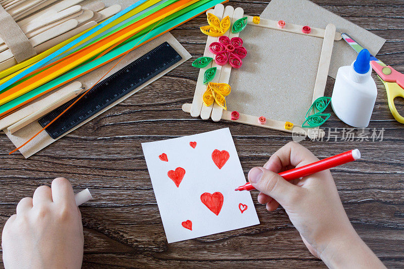 孩子画的细节的红心的细节到一个礼品相框木制的棍棒。手工制作的。儿童创意项目、手工艺品、儿童工艺品。