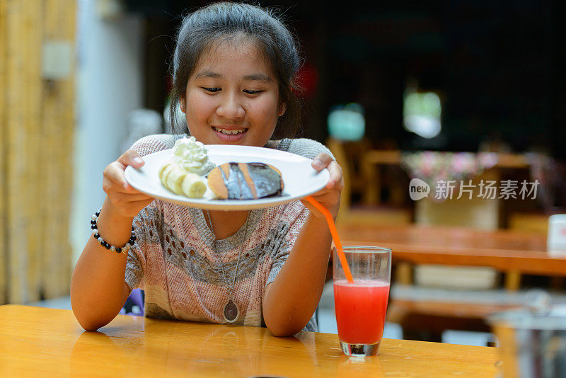 年轻的亚洲女人在餐厅用餐时放松的肖像