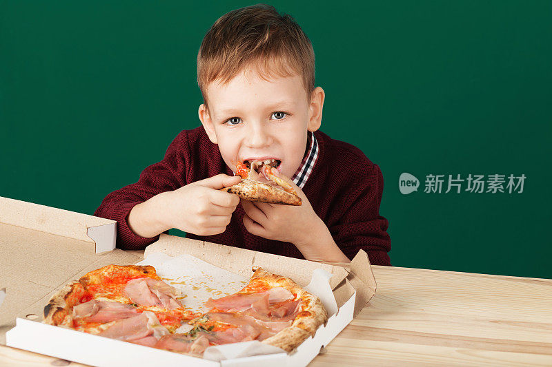 一个男生正在吃比萨饼当午餐。儿童不健康饮食观念。