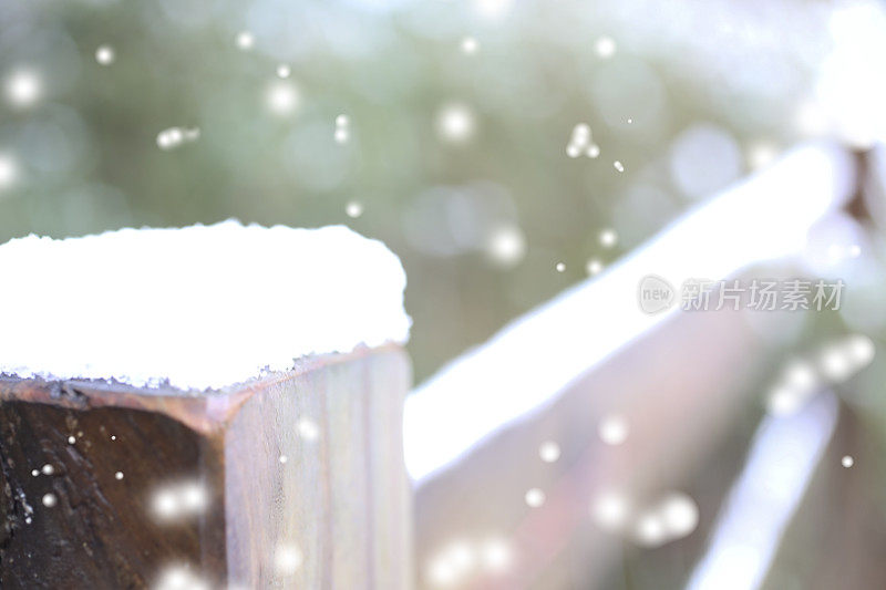 冬天的雪落在户外景观与篱笆柱。