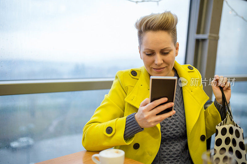 年轻漂亮的女人在咖啡馆里喝着咖啡