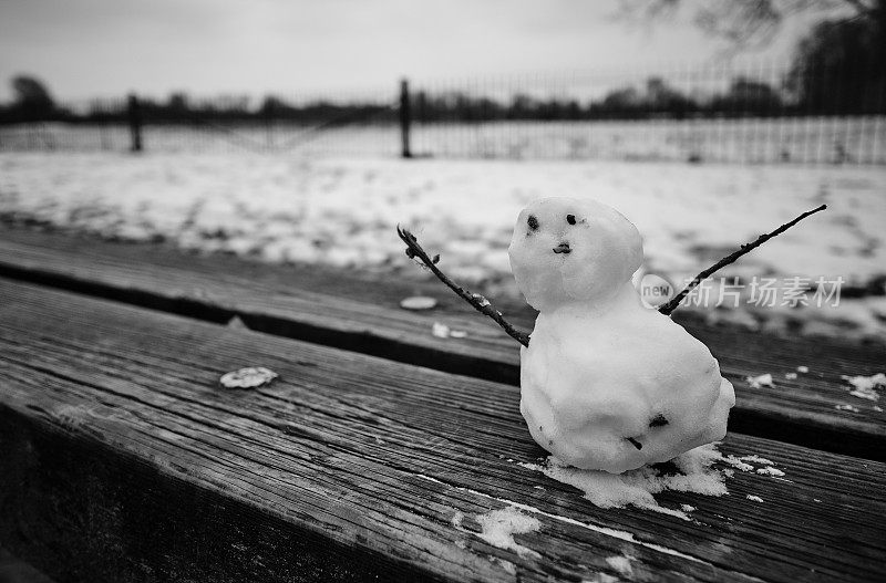 可爱的小雪人和雪地的背景