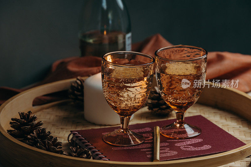 一对葡萄酒在舒适的烛光下在室内的桌子上