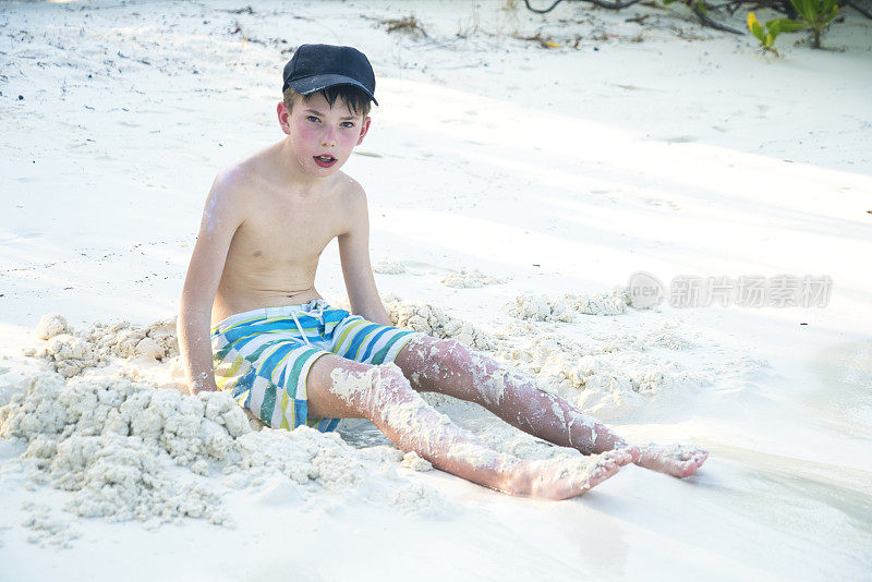 正面的小男孩坐在沙滩上的小岛屿海滩在四月，马尔代夫