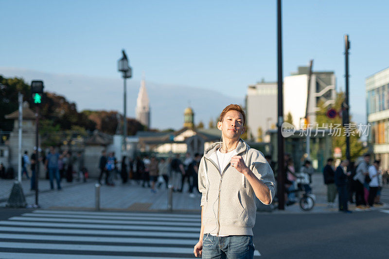 年轻人戴着耳机听音乐，在街上跳舞