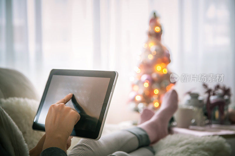 圣诞节网上购物-女性在圣诞节使用平板电脑