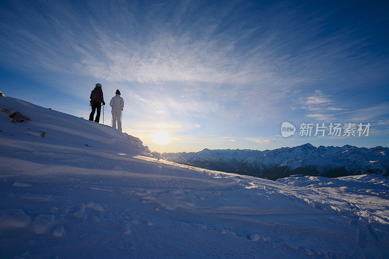 朋友滑雪。滑雪者在阳光明媚的滑雪胜地滑雪，夕阳下的白云石山在意大利。