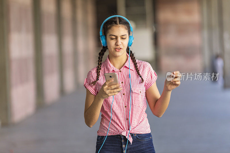 少女走在街上听着音乐