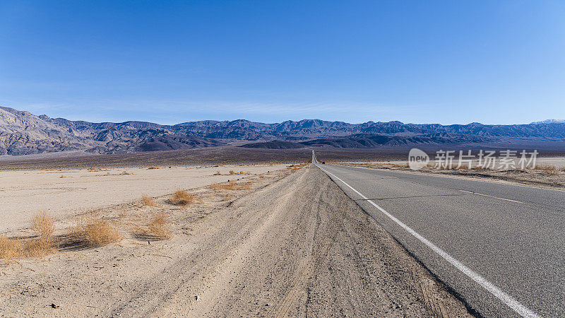 在美国加州死亡谷的高速公路上，一辆汽车在冬季行驶。