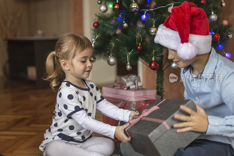 女孩把圣诞礼物送给她的弟弟