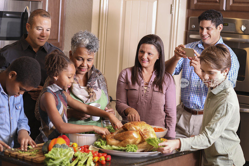 多样化的家庭在家庭厨房里烹饪感恩节晚餐。