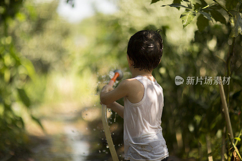 幼童在夏天在户外玩水管