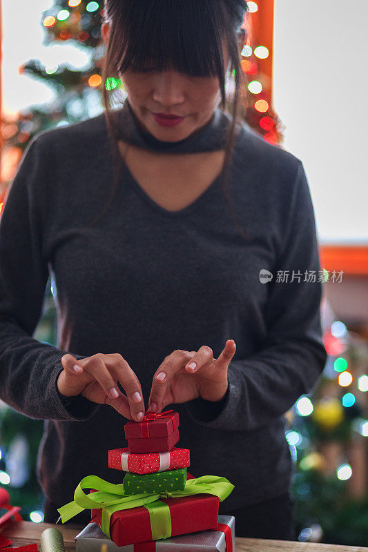 年轻的亚洲妇女包装圣诞礼物