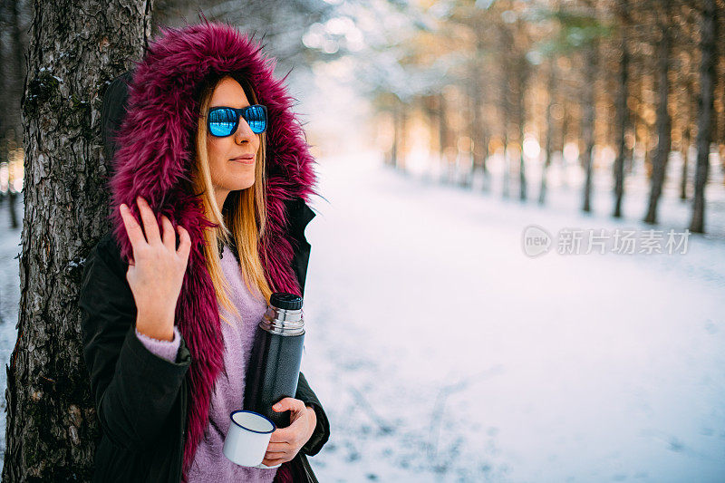 在雪域森林里喝咖啡的可爱女人