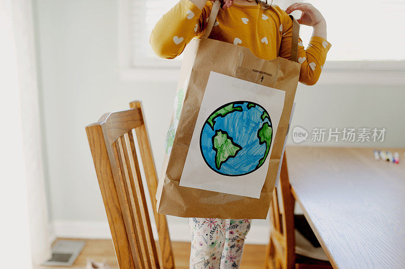 小女孩穿着纸袋地球日服装
