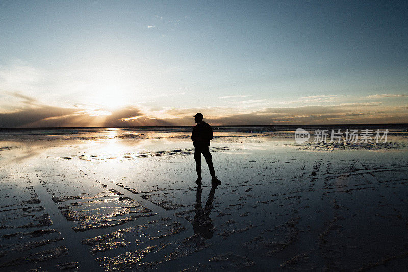 夕阳下，乌尤尼盐沼里，一个人走在路上