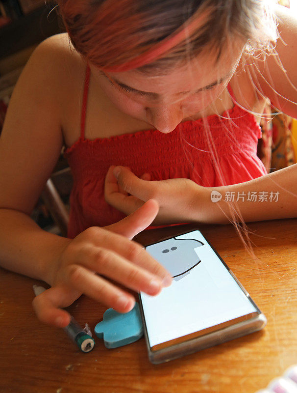 一个女孩在用手机画画。