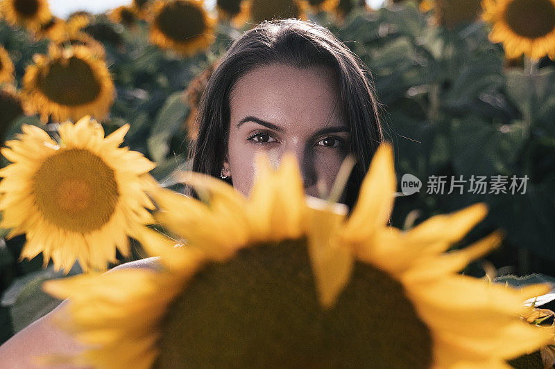 青少年的精神。向日葵的脸。一个年轻女孩的肖像在向日葵植物在夏天。旅行和享受。生态旅游。