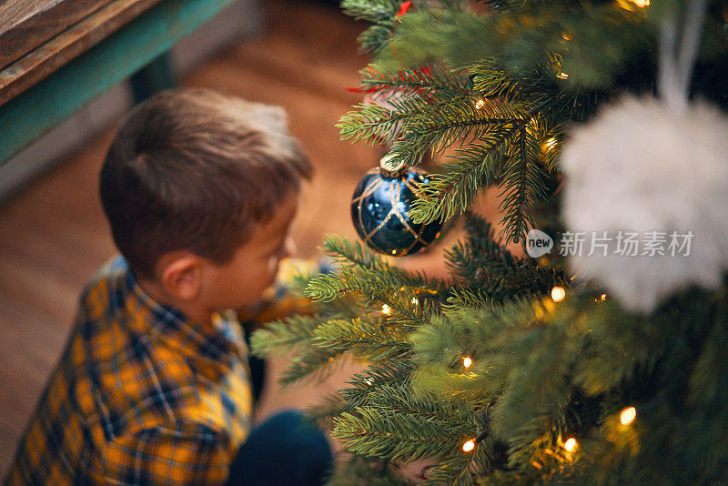 小孩子用装饰品和圣诞灯装饰圣诞树