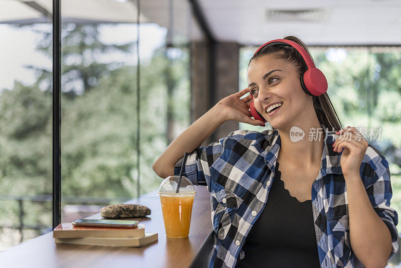 一个漂亮的女人用耳机听手机里的音乐