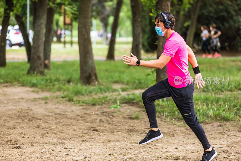 晨跑，一个戴着医用口罩的男人在公园里跑步。阿联酋，健身，运动，锻炼和健康的生活方式的概念。