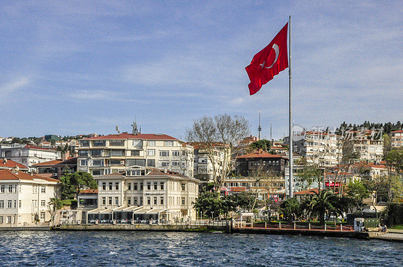 博斯普鲁斯海峡沿岸的一组建筑和土耳其伊斯坦布尔市的一面巨大的土耳其国旗。