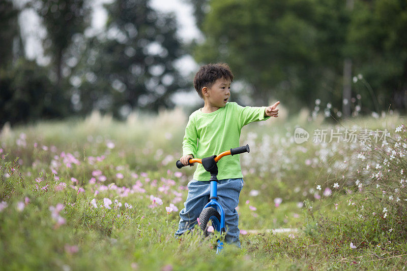 一个小男孩在户外学骑自行车