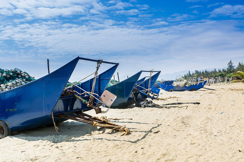 中国广东阳江阳溪，蓝色的渔船在蓝天白云的映衬下，在沙滩上。