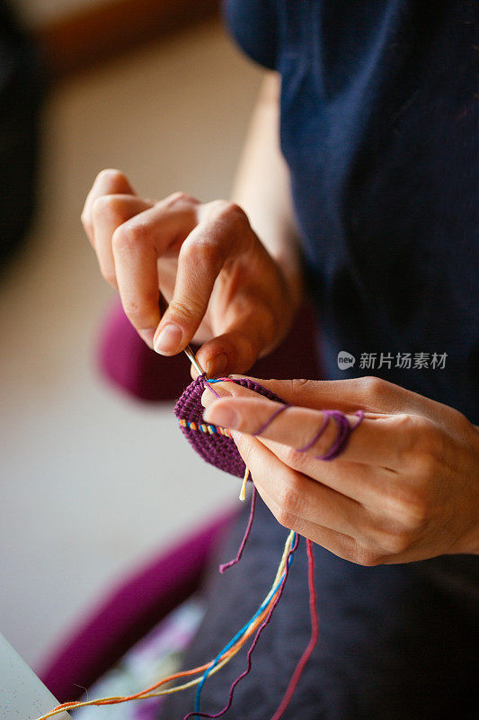 女手用针编织紫色围巾