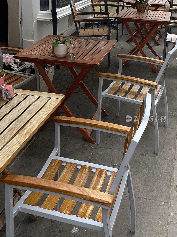 金属和木制的庭院庭院桌椅外面的路边餐厅，人行道上的咖啡馆和露天餐厅