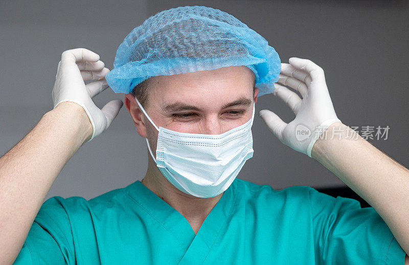 快乐的医生在一次成功的手术后摘下手术帽。