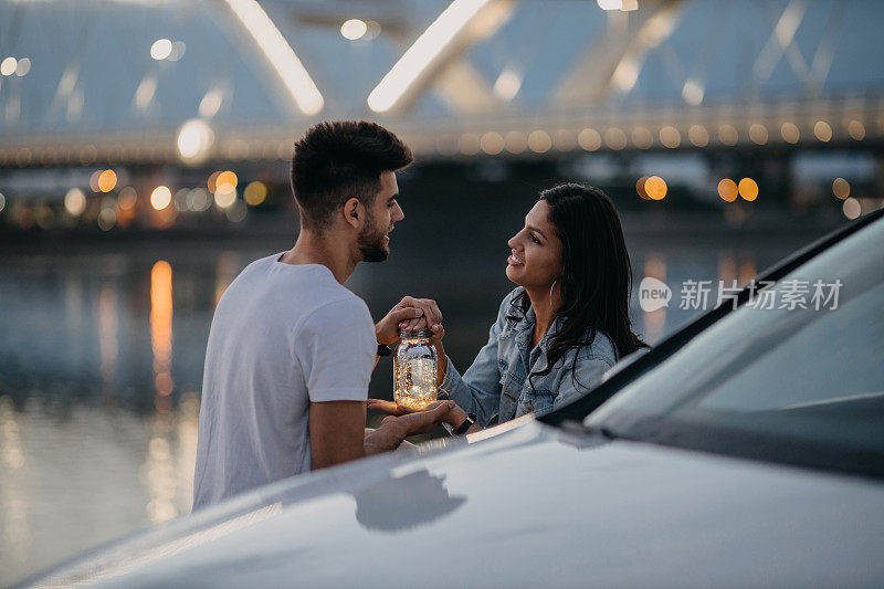 幸福的年轻夫妇花时间一起在河边的户外