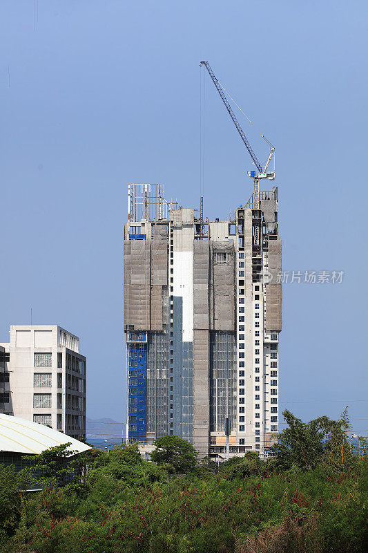 高层商业大厦正在建设中，顶部装有动力起重机